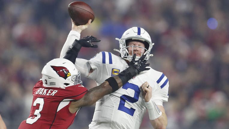 GLENDALE, ARIZONA - DECEMBER 25: Carson Wentz #2 of the Indianapolis Colts is hit by Budda Baker #3 of the Arizona Cardinals as he throws the ball during the second quarter at State Farm Stadium on December 25, 2021 in Glendale, Arizona. (Photo by Chris Coduto/Getty Images)