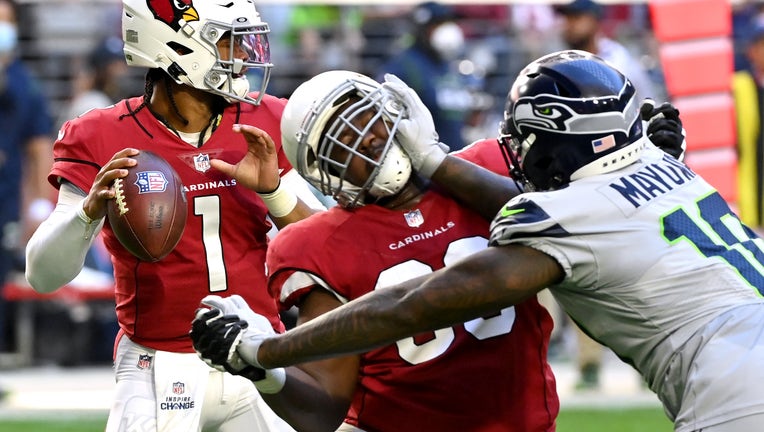 Kyler Murray #1 of the Arizona Cardinals looks to throw the ball as Benson Mayowa #10 of the Seattle Seahawks applies pressure during the first half at State Farm Stadium on January 09, 2022 in Glendale, Arizona. (Photo by Norm Hall/Getty Images)