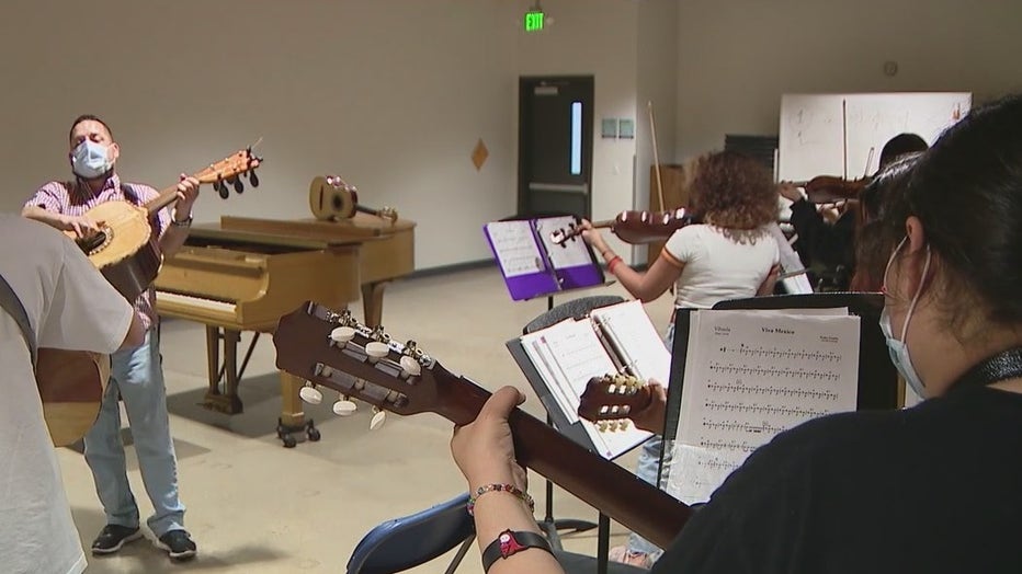 A teacher provides guitar lessons to students at Rosie's House in Phoenix.