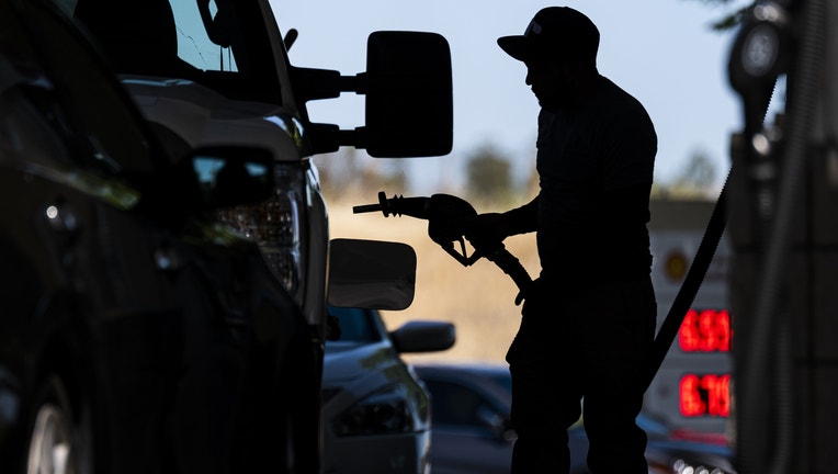 A customer holds a fuel nozzle at a gas station. (Photographer: David Paul Morris/Bloomberg via Getty Images)