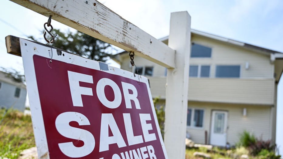 For sale by owner sign hangs in front of Long Island house