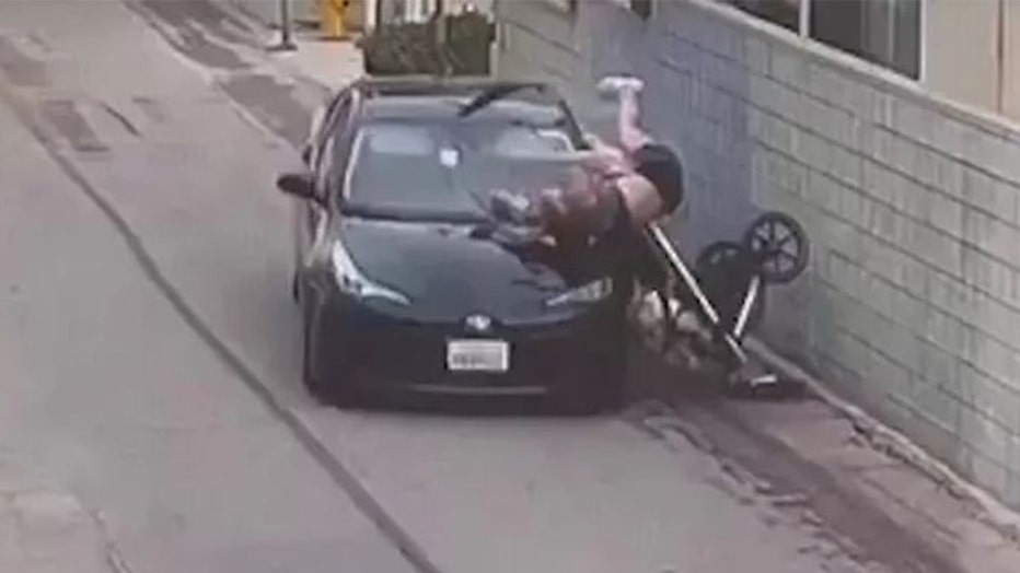 Surveillance video shows a dark-colored sedan attacking a woman walking her child in a stroller in Venice, California.  The woman's legs are above her head as she spins onto the hood of the car.