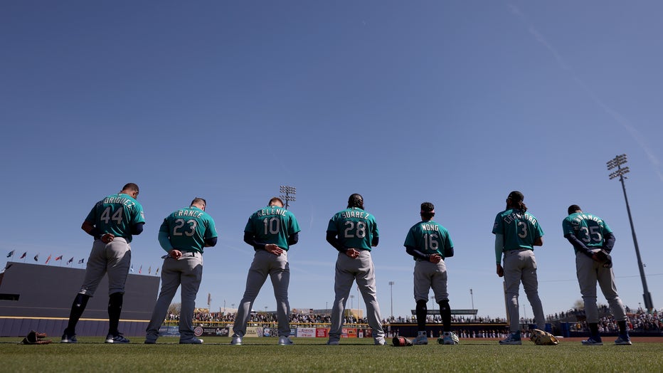 The Seattle Mariners lineup for the national anthem before playing the San Diego Padres during a spring training game at Peoria Stadium. (Photo by Steph Chambers/Getty Images)