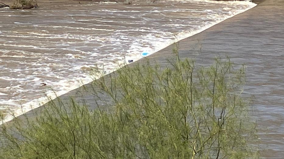 A bright blue paddleboard could be seen in the rushing waters.