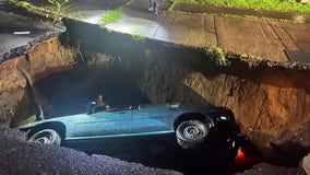 Sinkhole swallows car with driver and passenger inside after New York flooding