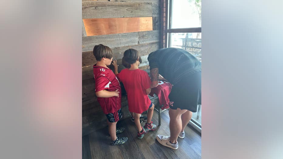Trey McBride signs Abner Wong's Cards jersey.
