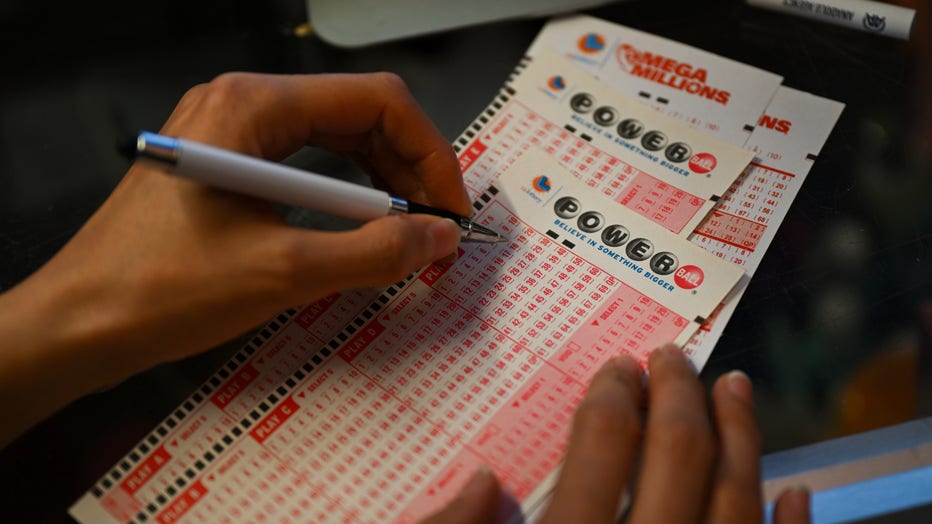 A person plays lottery at a store. (Photo by Tayfun Coskun/Anadolu Agency via Getty Images)