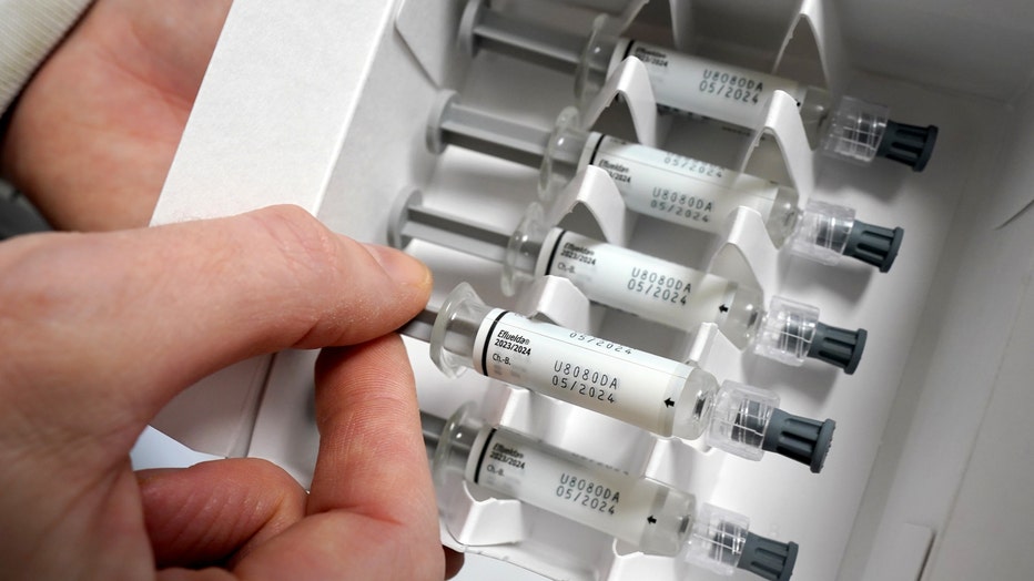 A doctor pulls a vaccine dose from a package containing a flu vaccine. (Photo by Marcus Brandt/picture alliance via Getty Images)