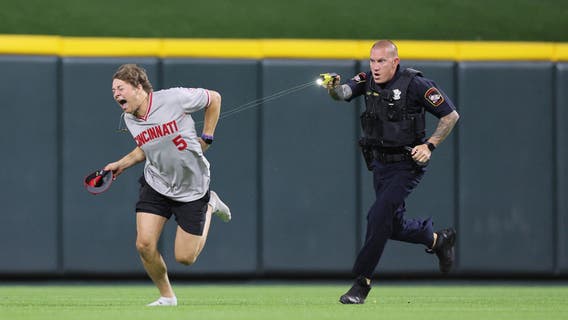 Reds fan tased and arrested after running onto field and doing backflip in front of officer