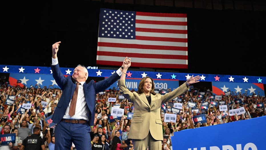 Minnesota Governor and 2024 Democratic vice presidential candidate Tim Walz (L) gestures toward US Vice President and 2024 Democratic presidential candidate Kamala Harris during a campaign event at Desert Diamond Arena in Glendale, Arizona, on August 9, 2024. (Photo by ROBYN BECK/AFP via Getty Images)