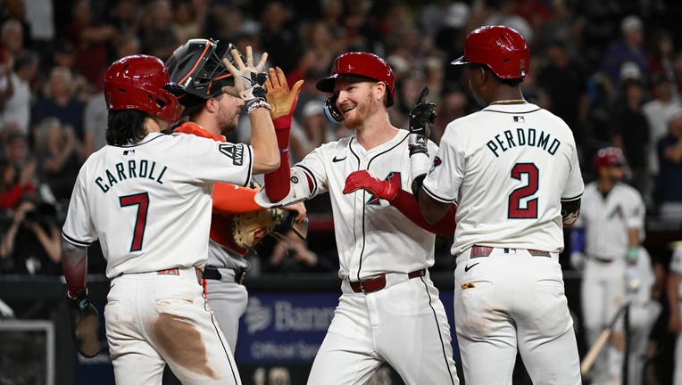 Pavin Smith #26 of the Arizona Diamondbacks celebrates his three-run home run with Corbin Carroll #7 and Geraldo Perdomo #2 against the San Francisco Giants in the eighth inning at Chase Field on September 25, 2024 in Phoenix, Arizona. (Photo by Norm Hall/Getty Images)