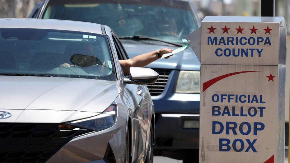 A voter places a ballot in a drop box outside of the Maricopa County Elections Department. (Photo by Justin Sullivan/Getty Images)