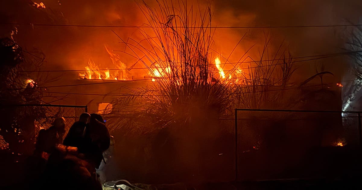 Wind-driven fire burns structures, power poles