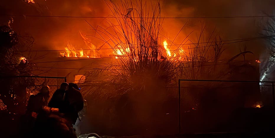 Wind-driven fire burns structures and power poles in Phoenix