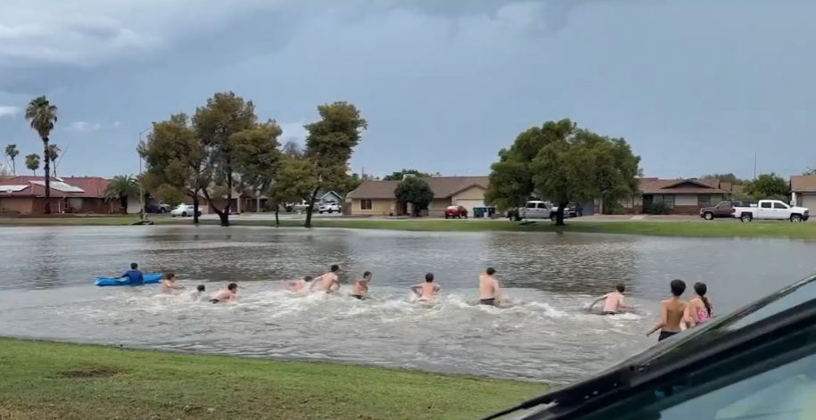 Drivers rescued from deep Mesa floodwaters, while kids swim in nearby flooded park