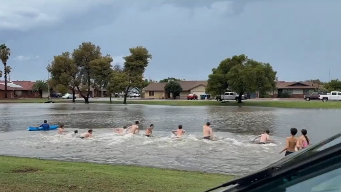 Drivers rescued from deep Mesa floodwaters, while kids swim in nearby flooded park