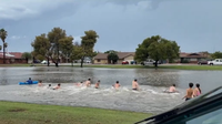 Drivers rescued from deep Mesa floodwaters, while kids swim in nearby flooded park