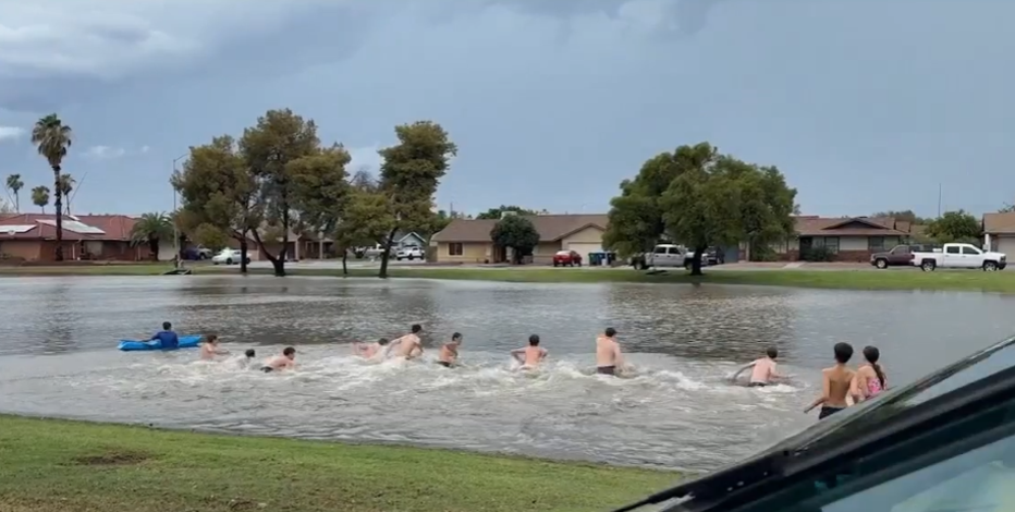 Drivers rescued from deep Mesa floodwaters, while kids swim in nearby flooded park