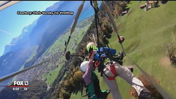 Hang-gliding passenger holds on for dear life after realizing harness not attached