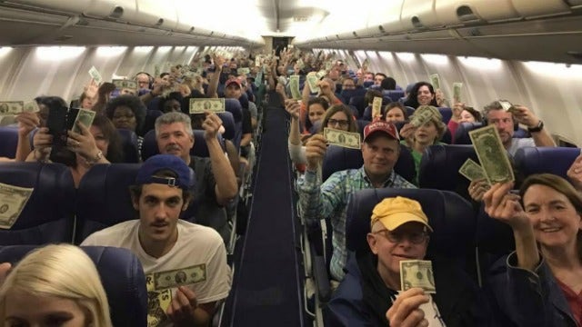 Man hands out $2 bills to fellow passengers on plane