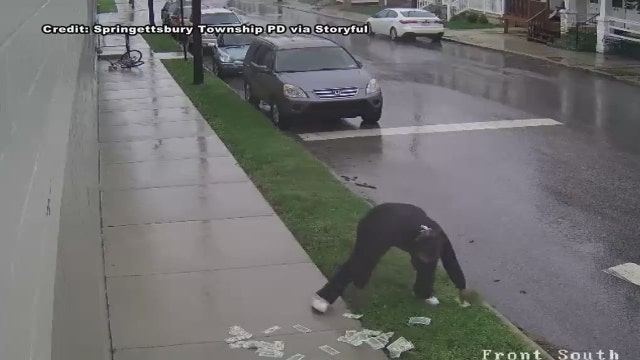 VIDEO: Bank robbery suspect drops cash on street