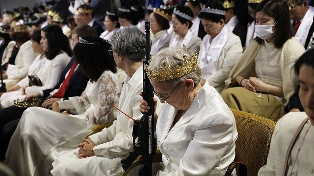 Worshipers clutching AR-15 rifles hold commitment ceremony