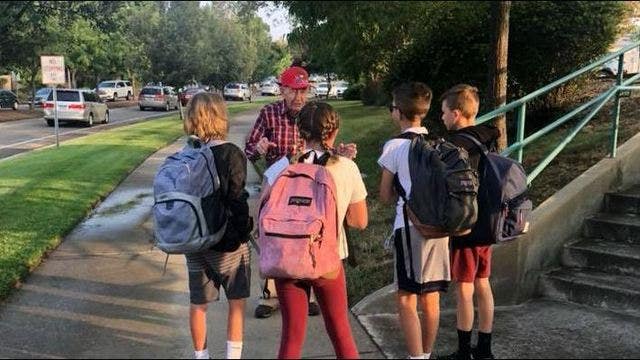 Elderly man gives students life advice, fist bumps before school