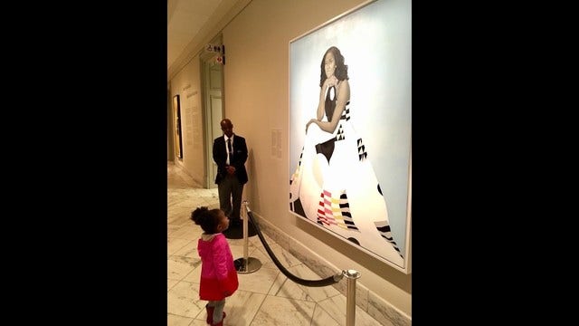Little girl stares in awe at Michelle Obama portrait