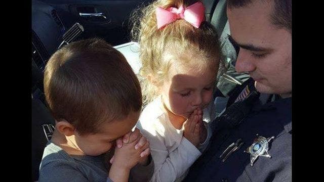 PHOTO: NC Deputy prays with two young kids before every shift