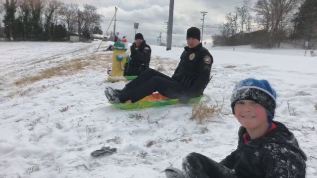 Officers challenge kids to sledding race