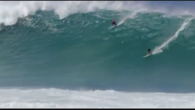 Surfers try to tame rare giant waves