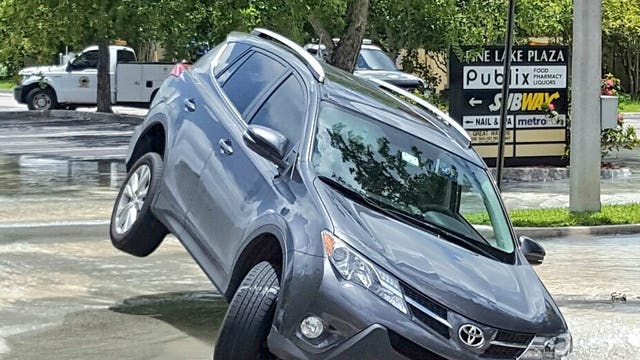 Sinkhole outside McDonald's swallows SUV