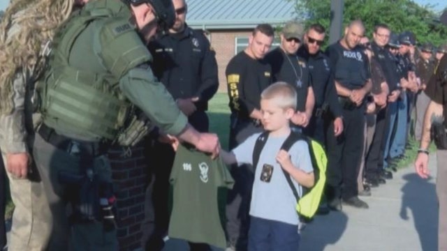 Slain officer's son greeted by officers on return to school