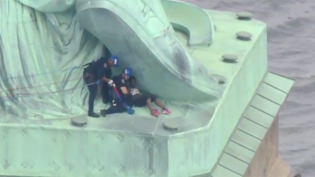 Police pull protester off Statue of Liberty