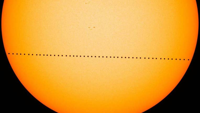 The black dot of Mercury crosses the sun's disk in a composite image made during the last Mercury transit in 2016. Photo via NASA.