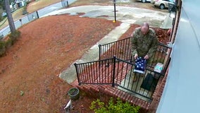 Man in fatigues filmed folding torn US flag