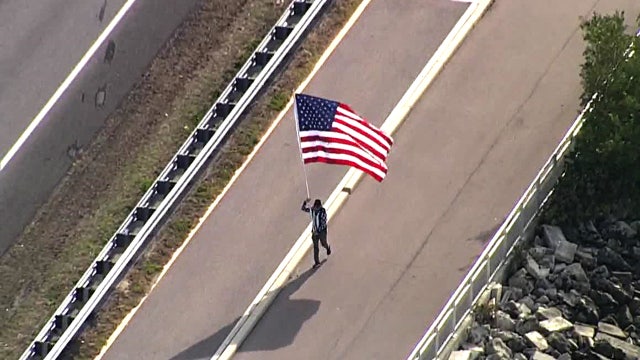 With U.S. flag in hand, 'Running Man' honors all essential workers along Courtney Campbell