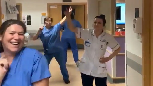 NHS staff maintain social distance while dancing to 'We Are Family' in hospital corridor