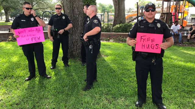 Officer holds 'free hugs' sign during peaceful protests in Polk County