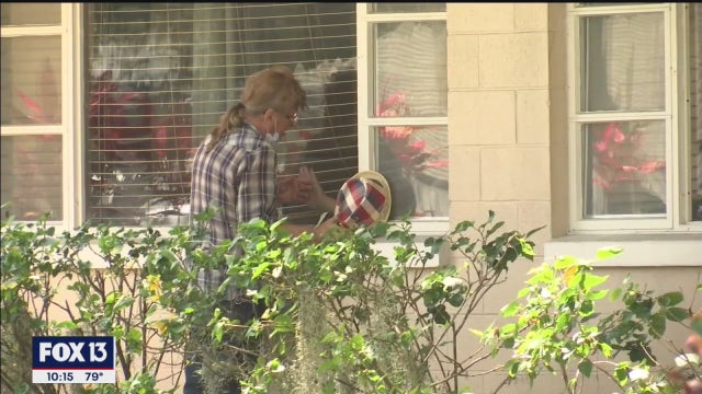 Manatee County man and wife hold hands through glass after months separated by COVID-19