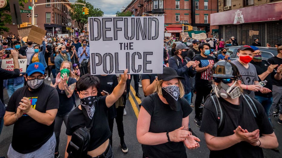 1b2a6905-A participant holding a Defund The Police sign at the