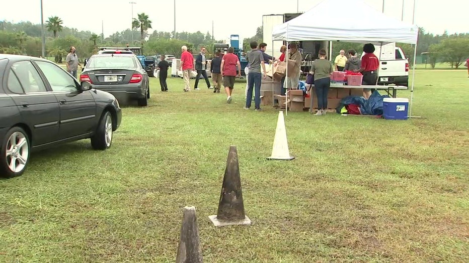 Cars lined up to receive boxes of food.