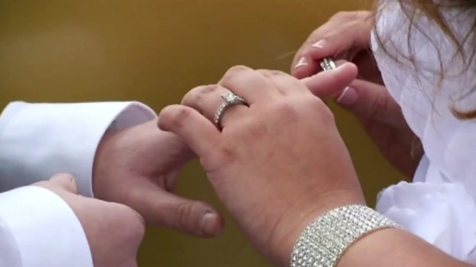 couple putting on rings at wedding