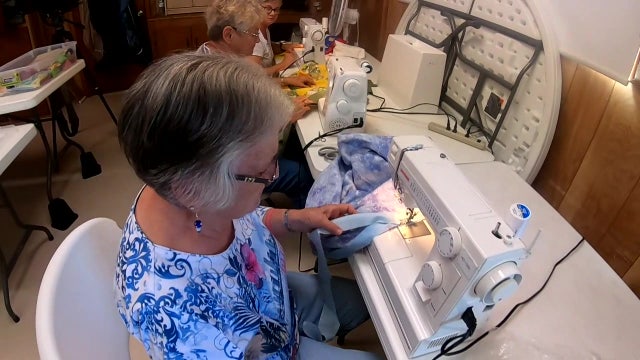 Women at a Frostproof RV resort bond while sewing blankets for migrants