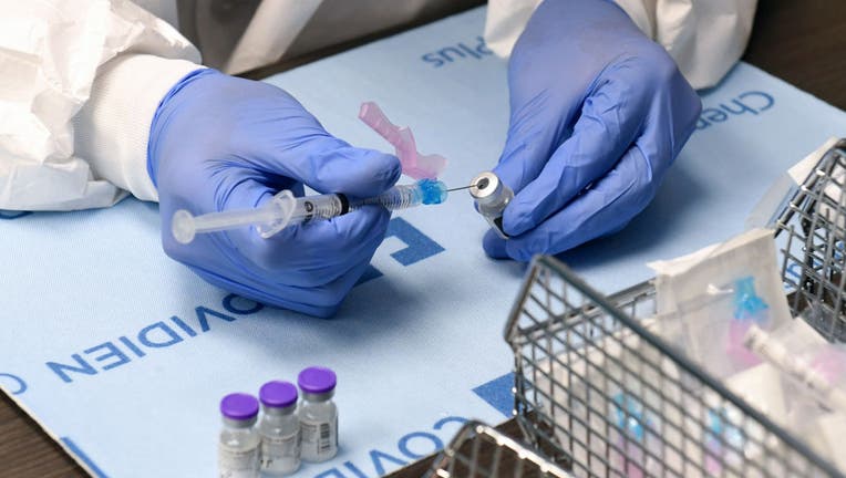 Student pharmacist Wilbur Quimba dilutes vials of the Pfizer-BioNTech COVID-19 vaccine at University Medical Center of Southern Nevada on December 16, 2020, in Las Vegas, Nevada.