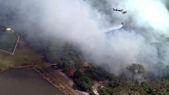Crews beat back brush fire threatening Holiday neighborhood