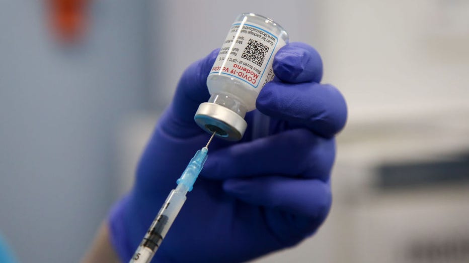 A health worker draws the Moderna COVID-19 vaccine  as she