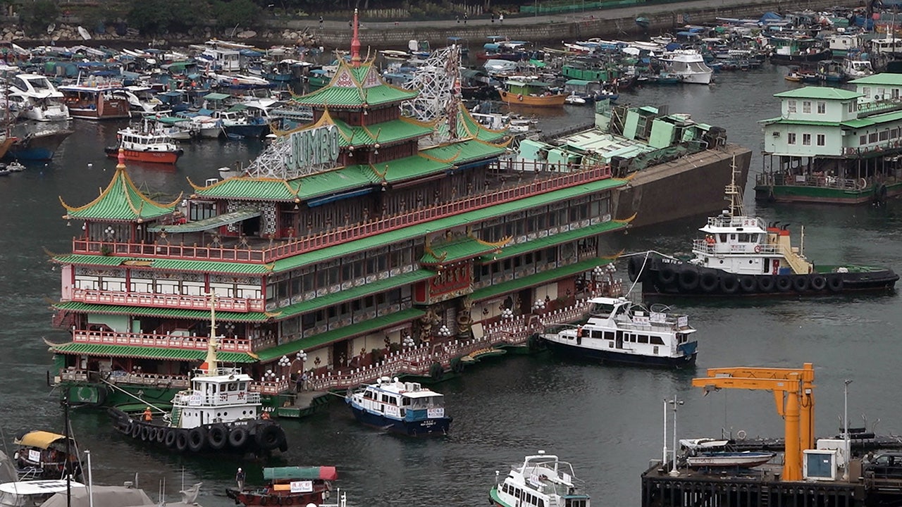 Restoran terapung jumbo yang ditarik dari pelabuhan Hong Kong terbalik