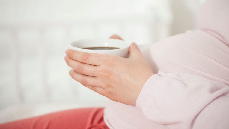 Schwangere mit Tasse Kaffe / Tee