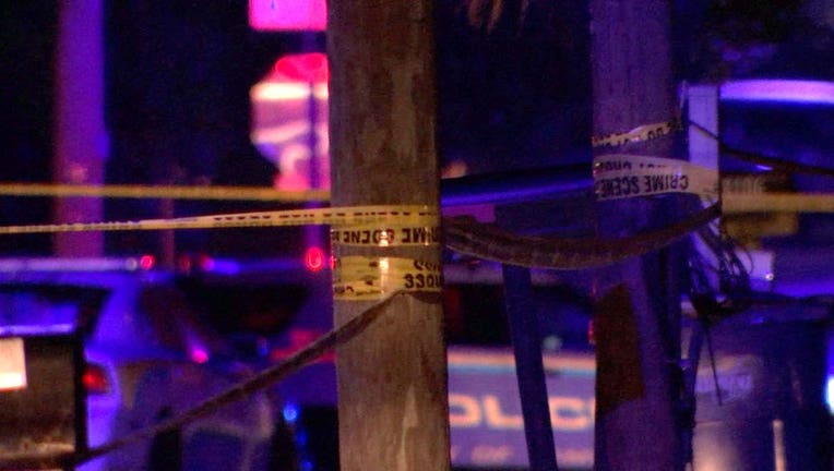 Photo: Crime scene tape strung around wooden poles at shooting investigation